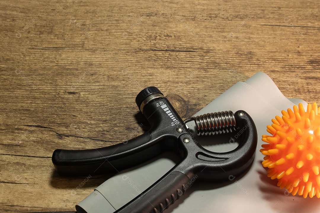 Aperto de mão para exercícios de pulso e cotovelo em uma mesa de madeira