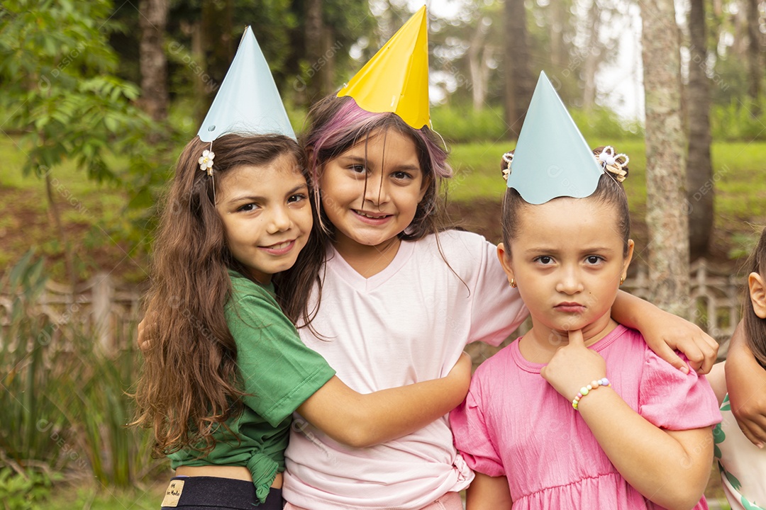 Lindas crianças felizes usando chapéu de aniversário