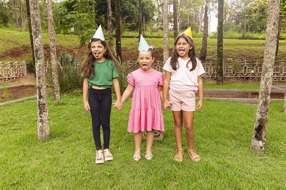 Lindas crianças felizes usando chapéu de aniversário