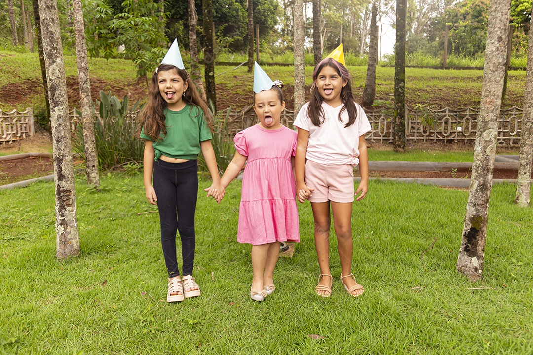 Lindas crianças felizes usando chapéu de aniversário