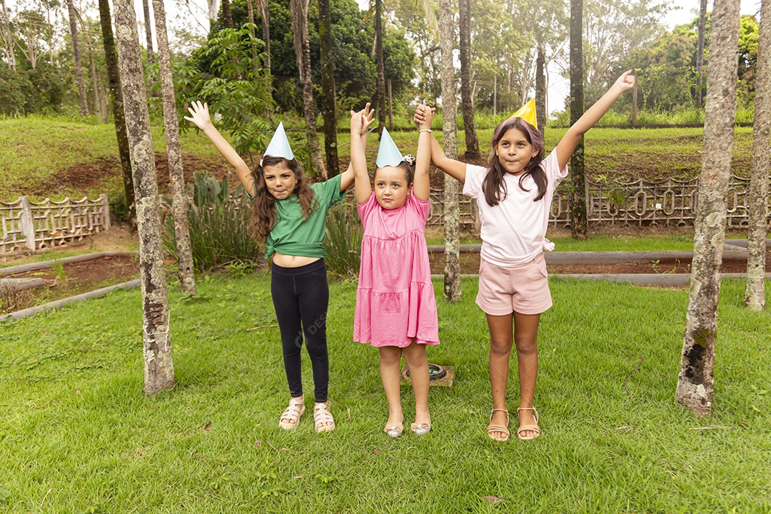Lindas crianças felizes usando chapéu de aniversário