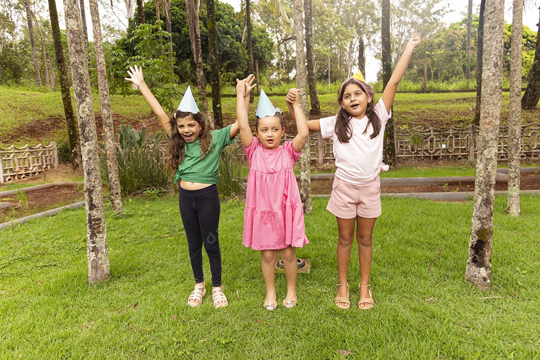 Lindas crianças felizes usando chapéu de aniversário