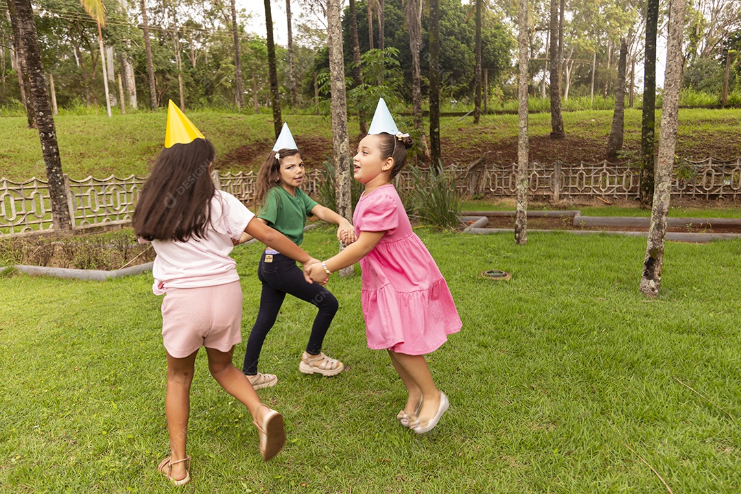Lindas crianças felizes usando chapéu de aniversário