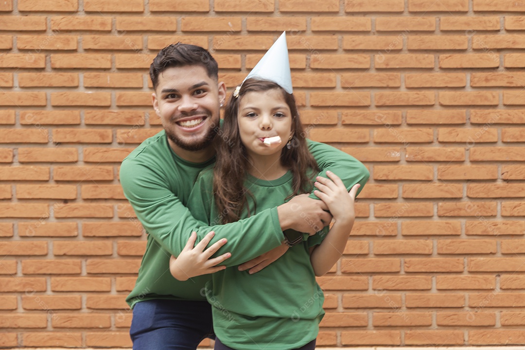 Homem jovem ao lado de linda garotinha aniversariante