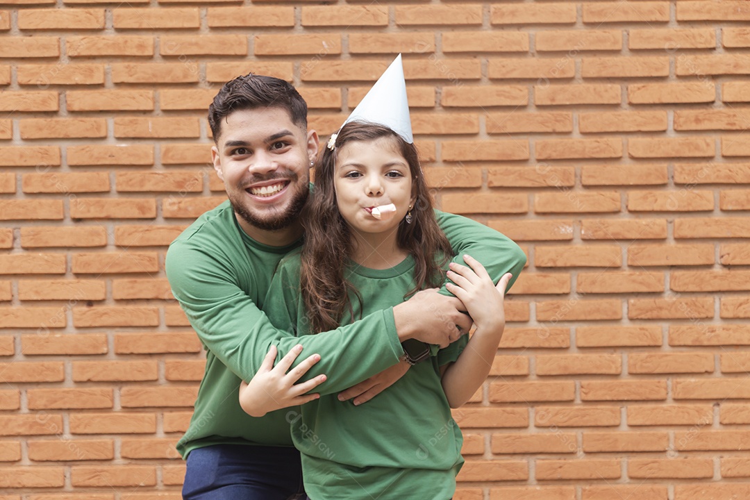 Homem jovem ao lado de linda garotinha aniversariante