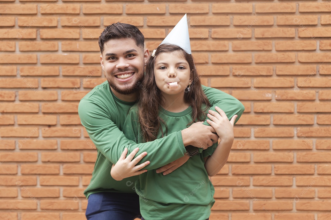 Homem jovem ao lado de linda garotinha aniversariante