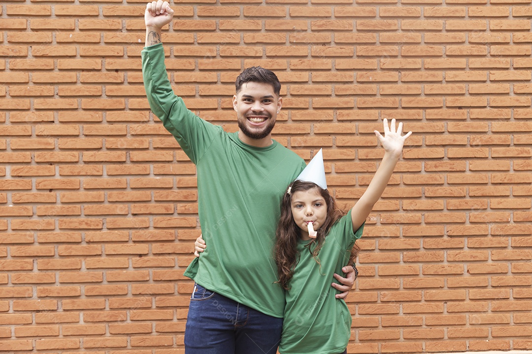 Homem jovem ao lado de linda garotinha aniversariante