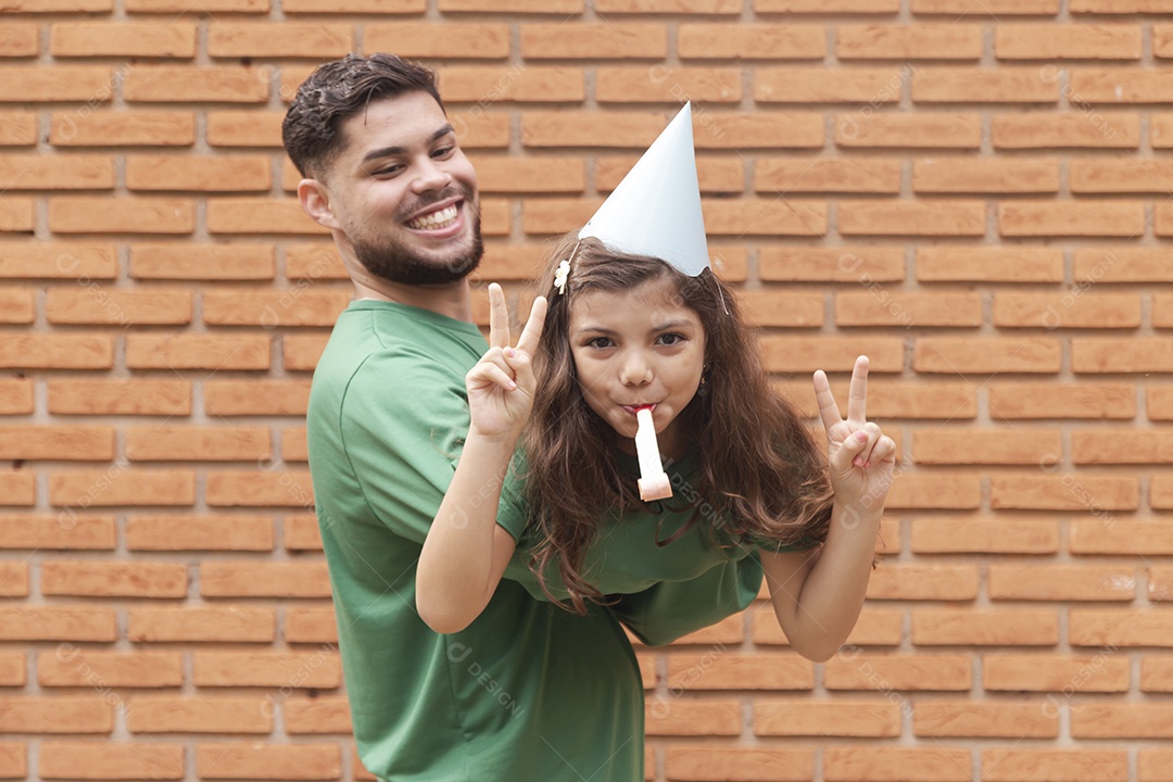 Homem jovem ao lado de linda garotinha aniversariante