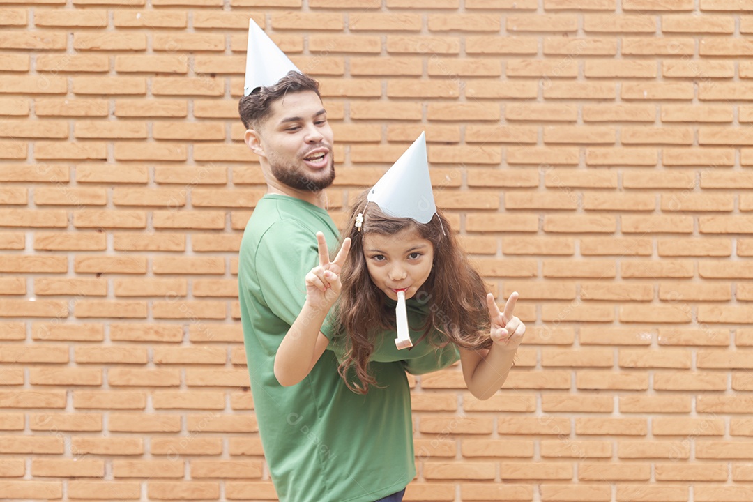 Homem jovem ao lado de linda garotinha aniversariante