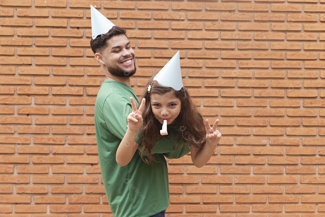 Homem jovem ao lado de linda garotinha aniversariante