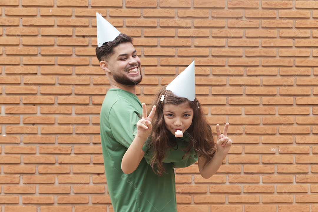 Homem jovem ao lado de linda garotinha aniversariante