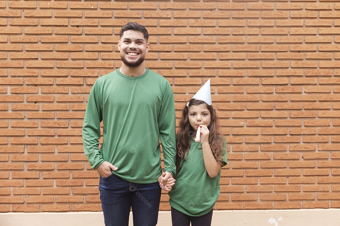 Homem jovem ao lado de linda garotinha aniversariante