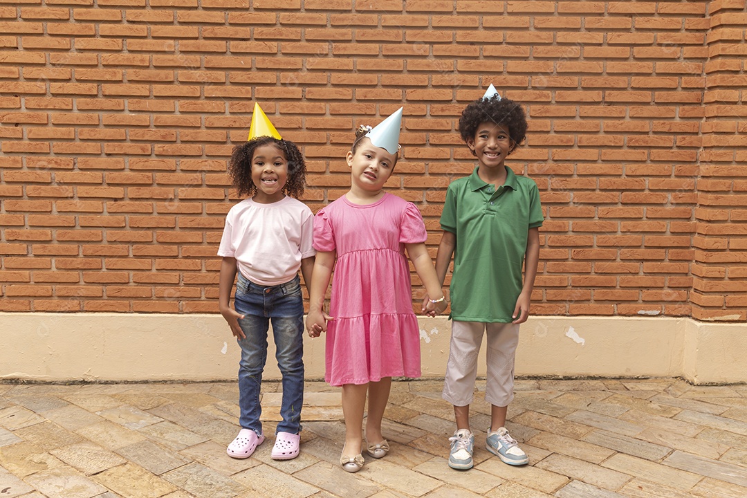 Lindas crianças felizes usando chapéu de aniversário
