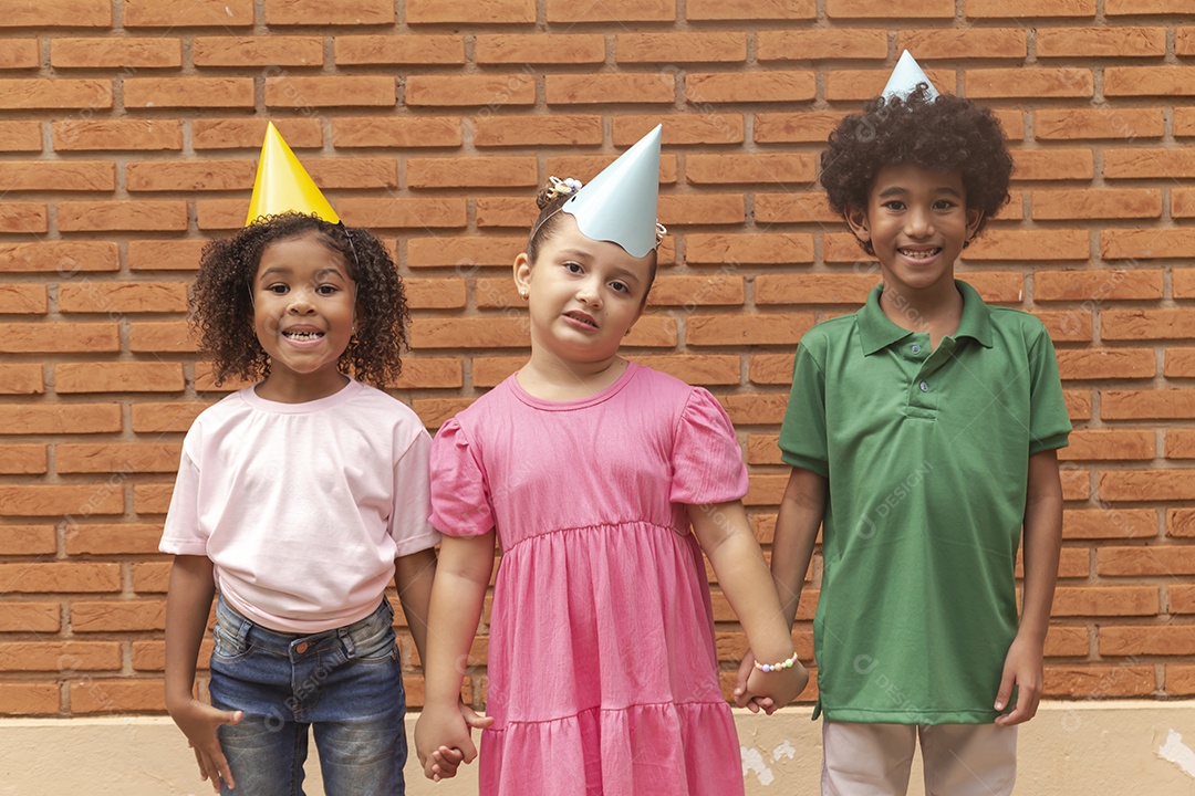 Lindas crianças felizes usando chapéu de aniversário