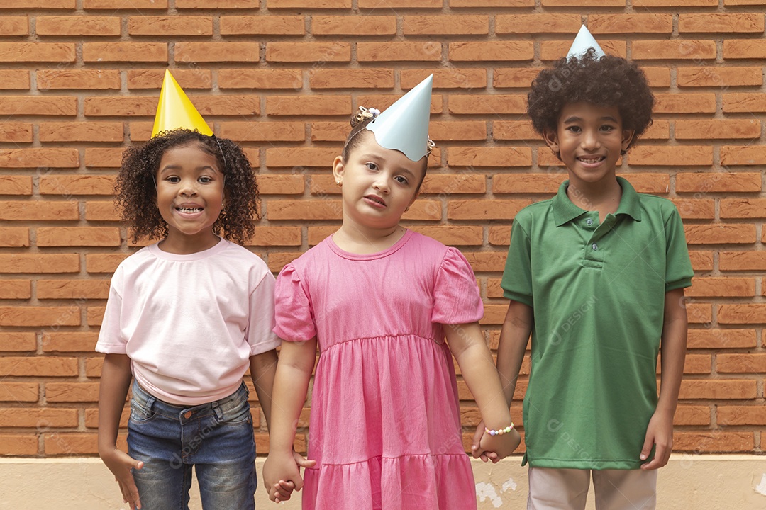Lindas crianças felizes usando chapéu de aniversário