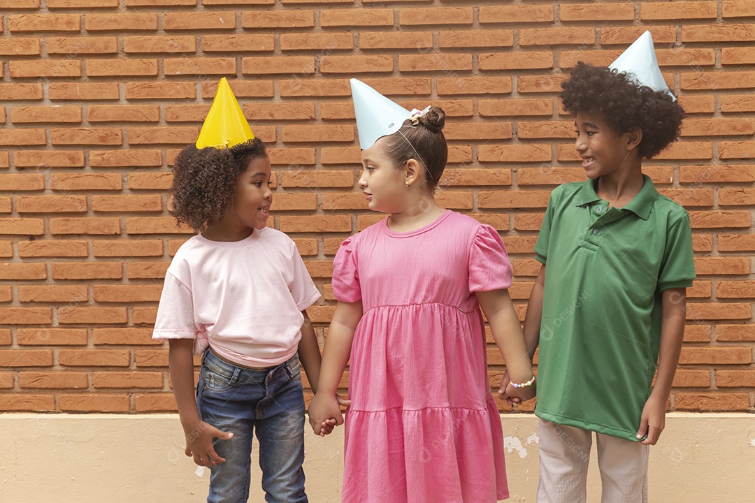 Lindas crianças felizes usando chapéu de aniversário