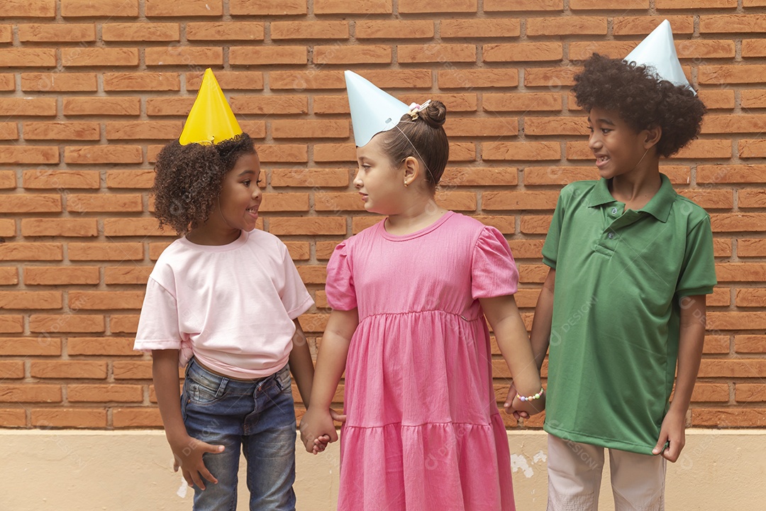 Lindas crianças felizes usando chapéu de aniversário