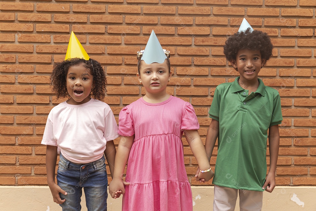 Lindas crianças felizes usando chapéu de aniversário