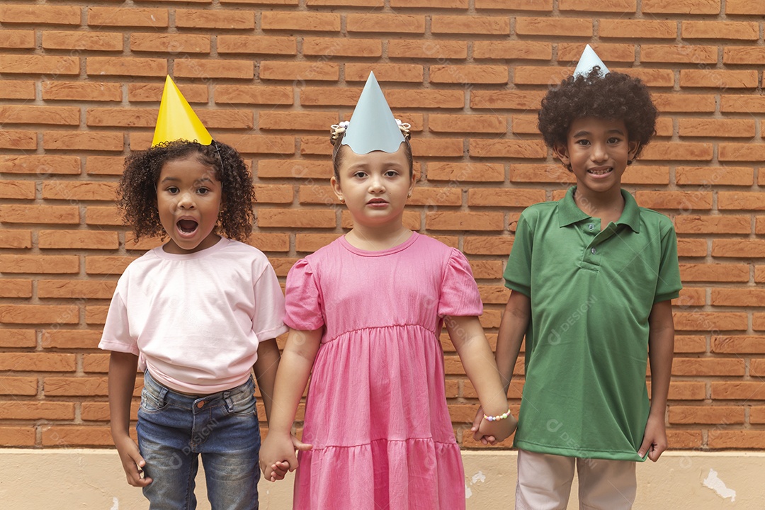 Lindas crianças felizes usando chapéu de aniversário