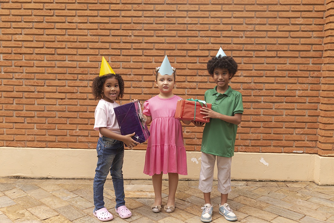 Lindas crianças felizes usando chapéu de aniversário