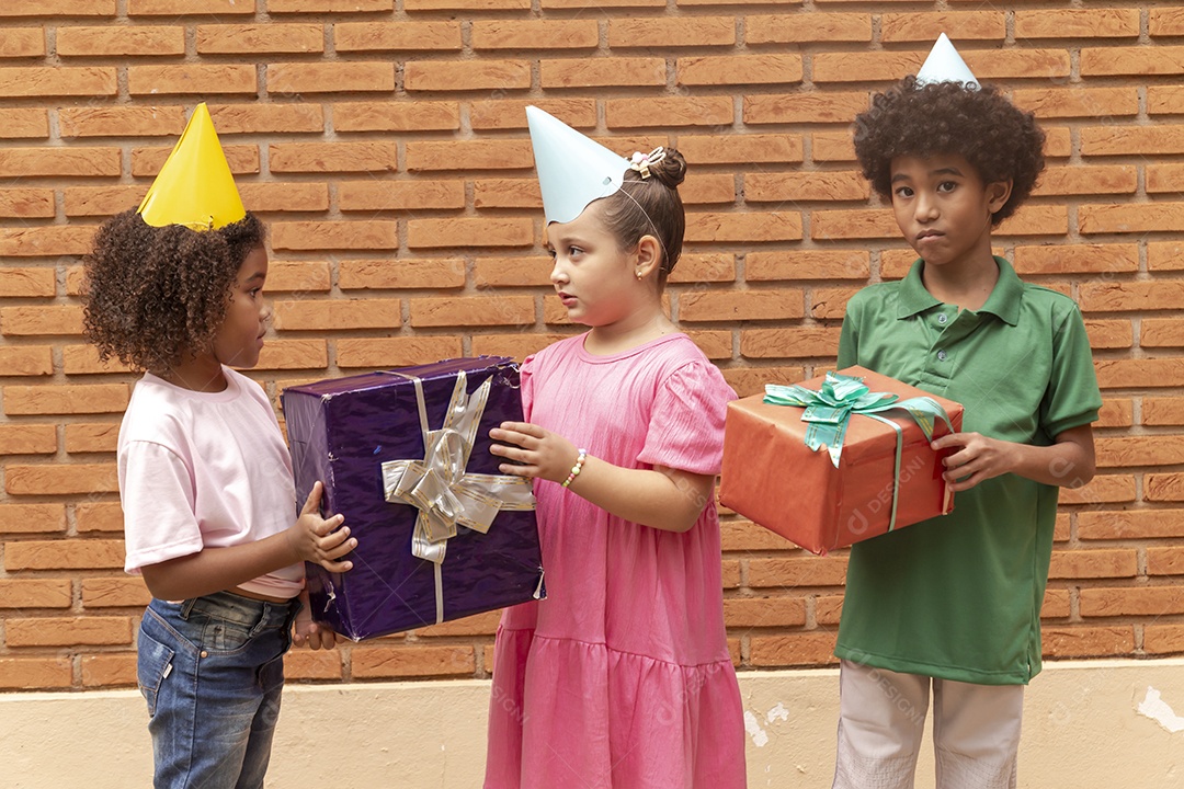 Lindas crianças felizes usando chapéu de aniversário