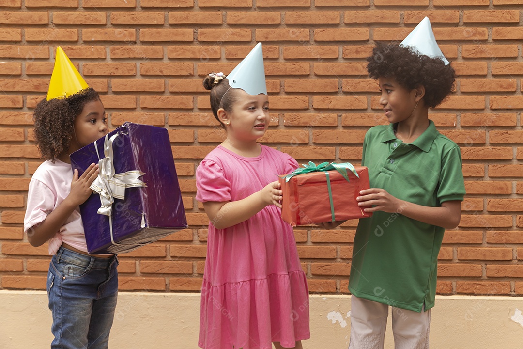 Lindas crianças felizes usando chapéu de aniversário