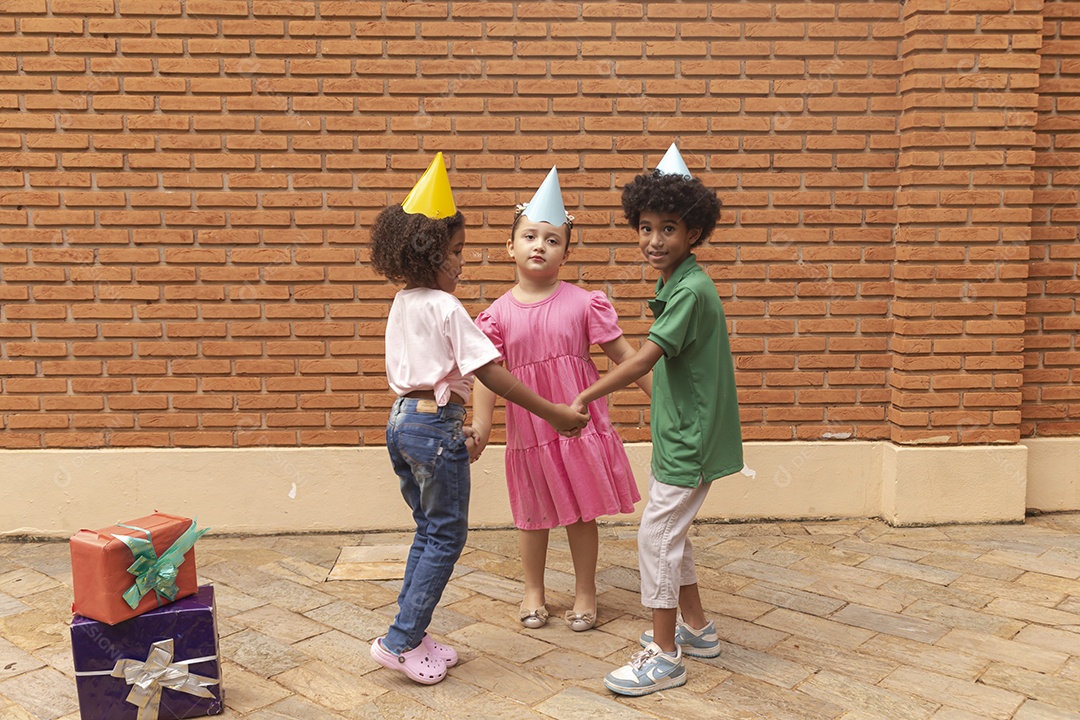 Lindas crianças felizes usando chapéu de aniversário