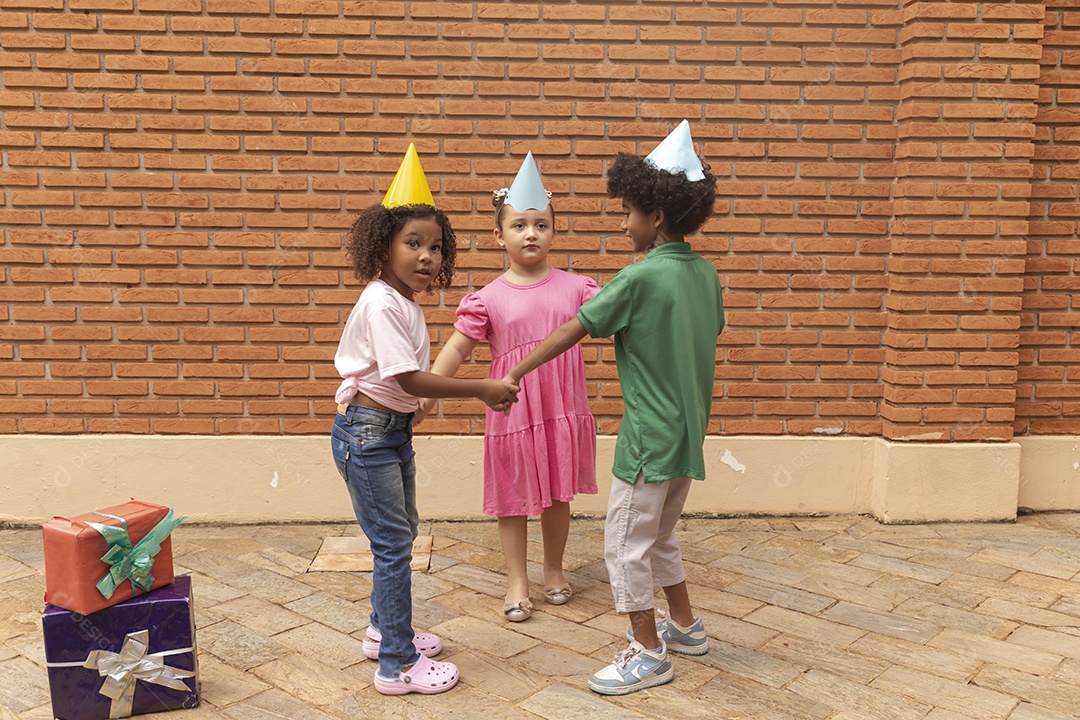 Lindas crianças felizes usando chapéu de aniversário