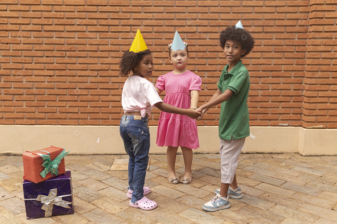 Lindas crianças felizes usando chapéu de aniversário