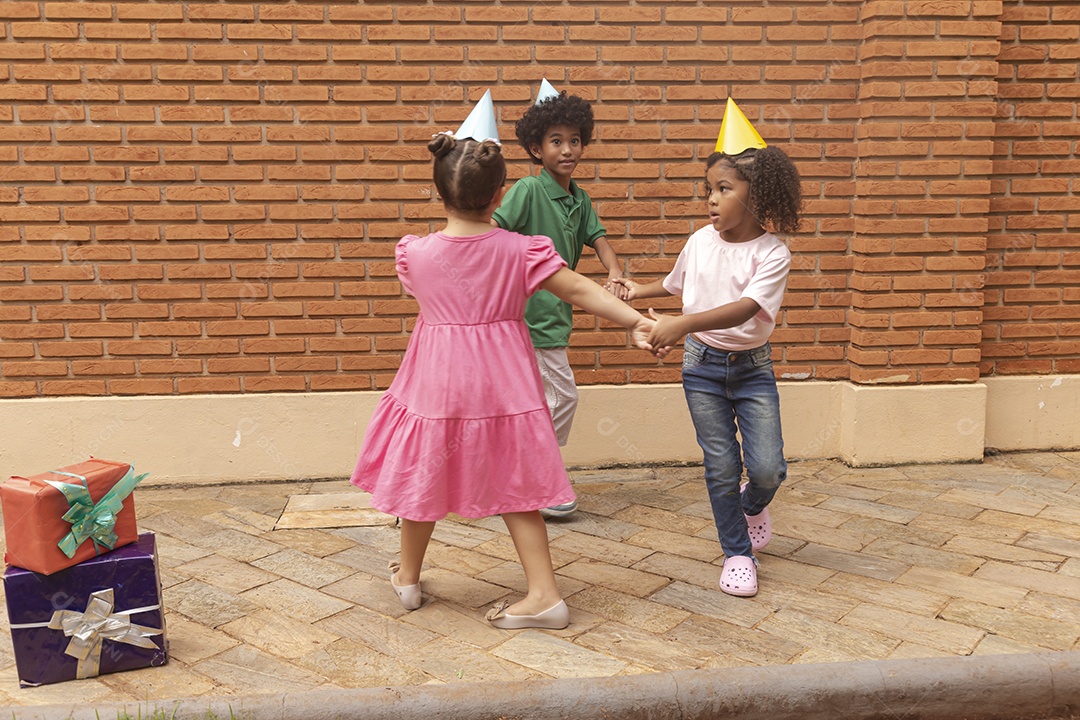 Lindas crianças felizes usando chapéu de aniversário