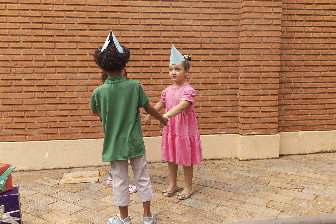 Lindas crianças felizes usando chapéu de aniversário