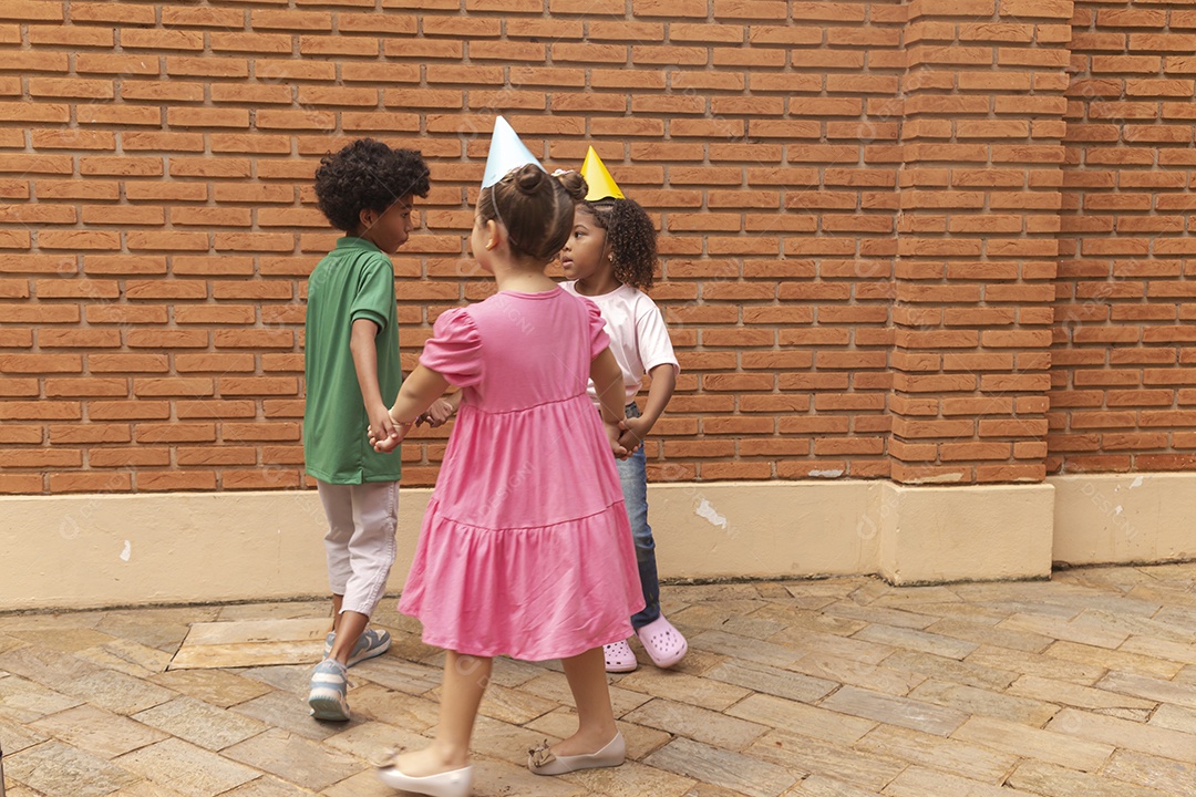 Lindas crianças felizes usando chapéu de aniversário