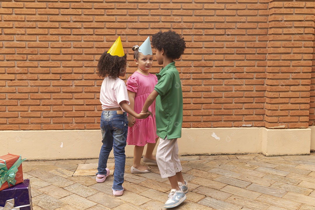 Lindas crianças felizes usando chapéu de aniversário