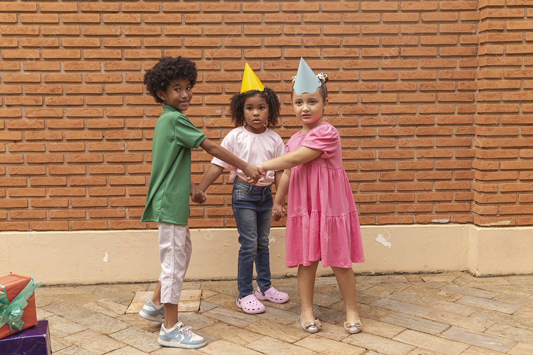 Lindas crianças felizes usando chapéu de aniversário