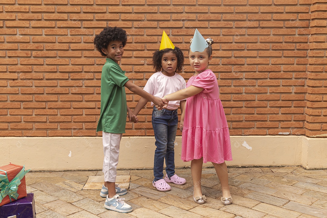 Lindas crianças felizes usando chapéu de aniversário