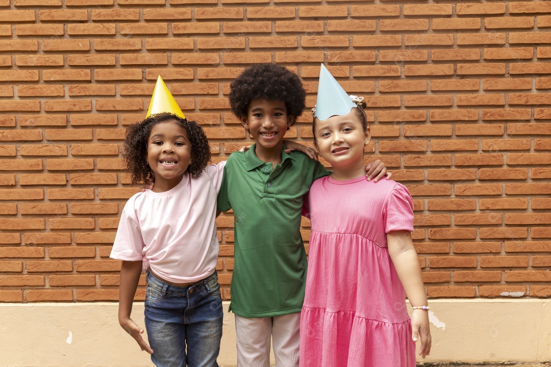 Lindas crianças felizes usando chapéu de aniversário