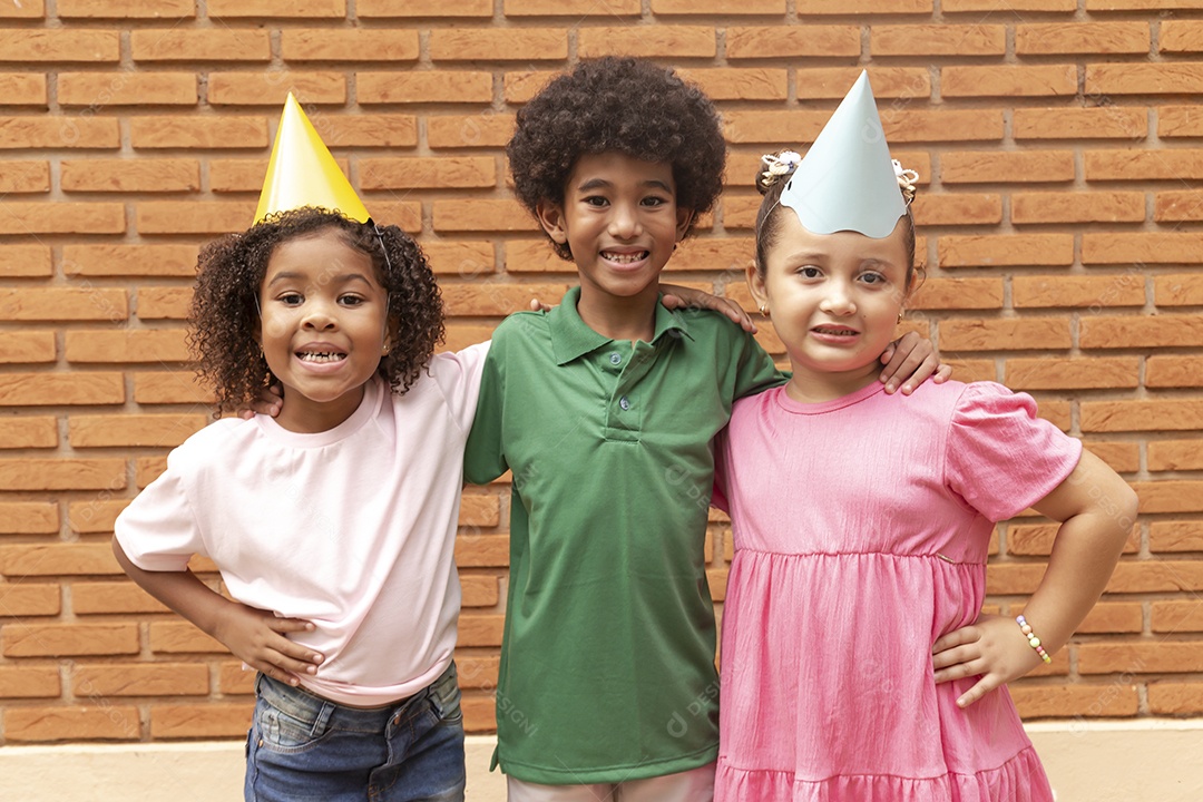 Lindas crianças felizes usando chapéu de aniversário