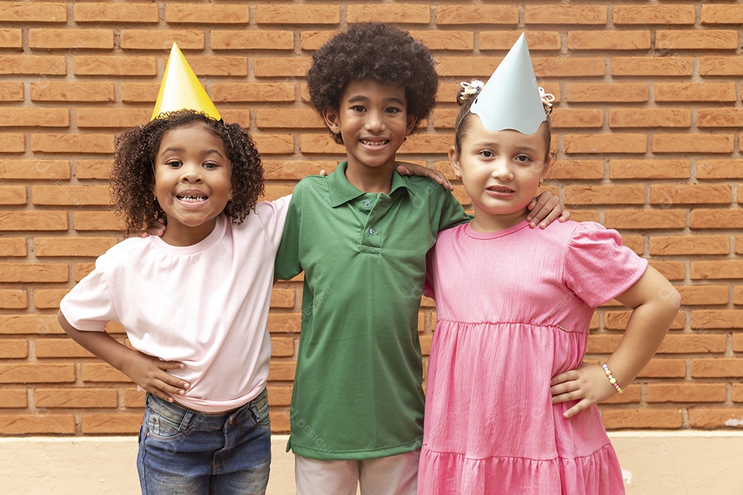 Lindas crianças felizes usando chapéu de aniversário