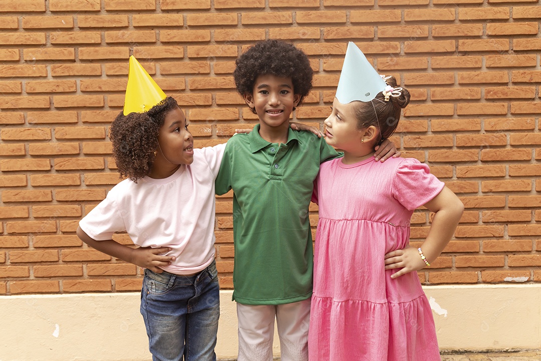 Lindas crianças felizes usando chapéu de aniversário