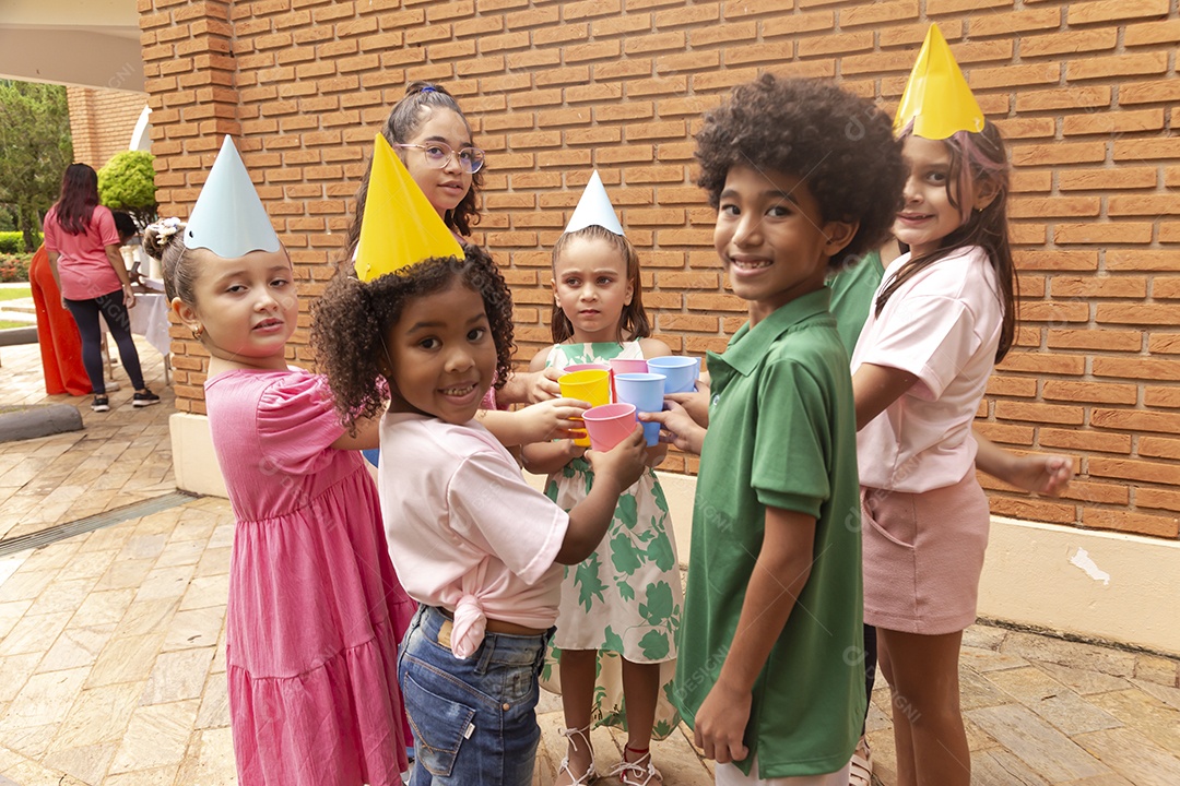 Lindas crianças felizes usando chapéu de aniversário