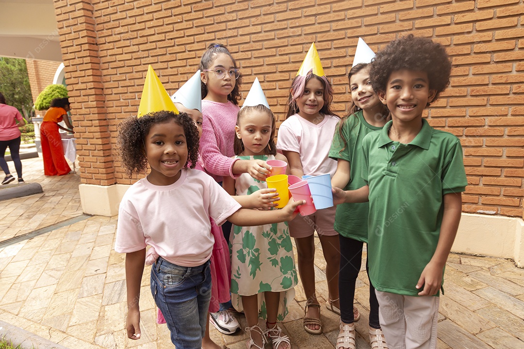 Lindas crianças felizes usando chapéu de aniversário