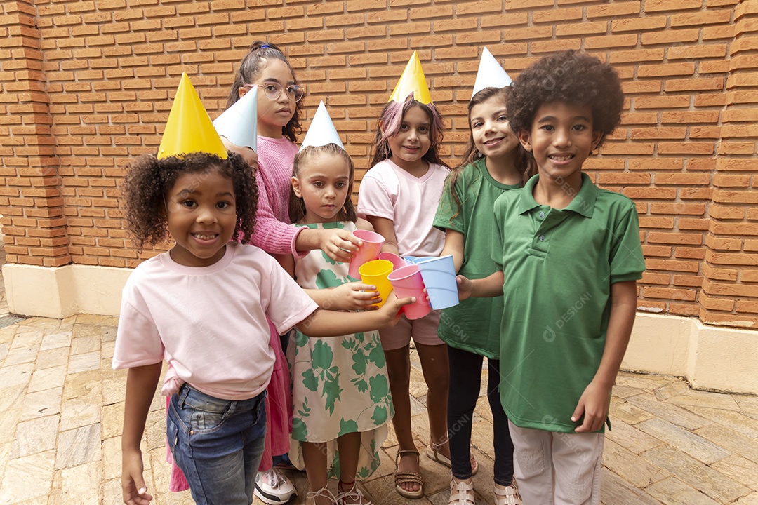 Lindas crianças felizes usando chapéu de aniversário