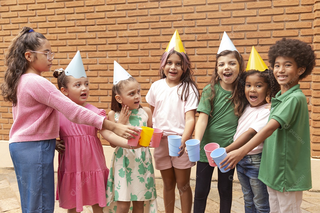 Lindas crianças felizes usando chapéu de aniversário