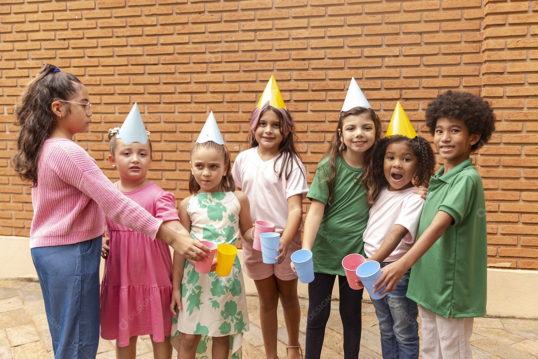 Lindas crianças felizes usando chapéu de aniversário