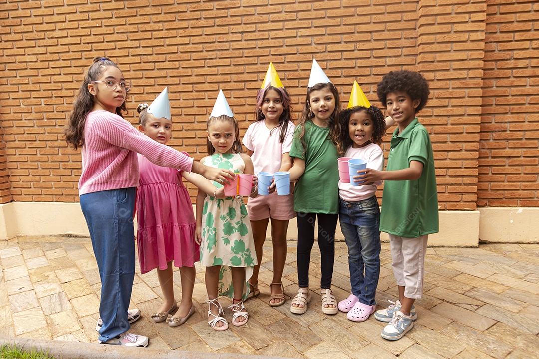 Lindas crianças felizes usando chapéu de aniversário