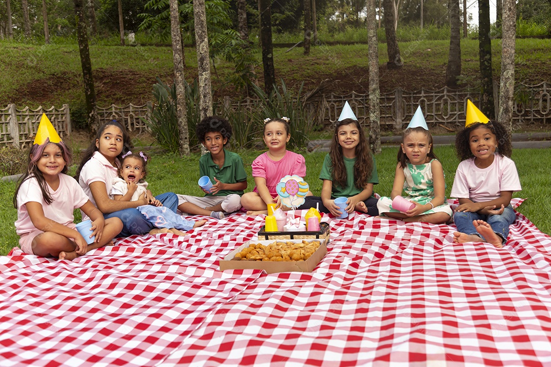 Lindas crianças felizes usando chapéu de aniversário