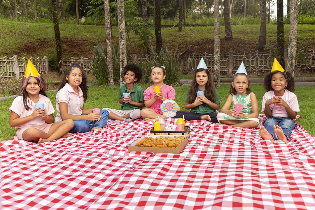 Lindas crianças felizes usando chapéu de aniversário