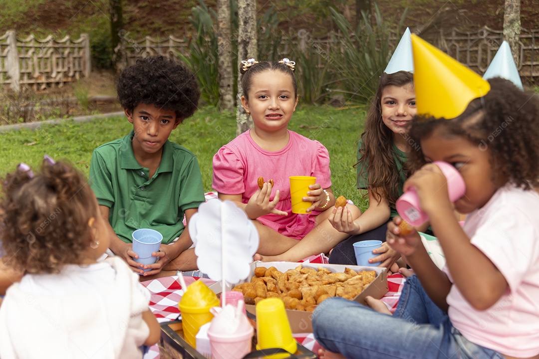 Lindas crianças felizes usando chapéu de aniversário