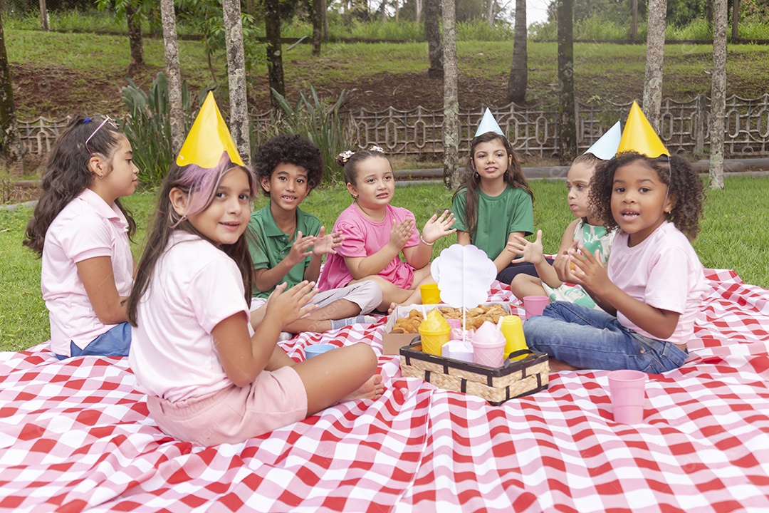 Lindas crianças felizes usando chapéu de aniversário