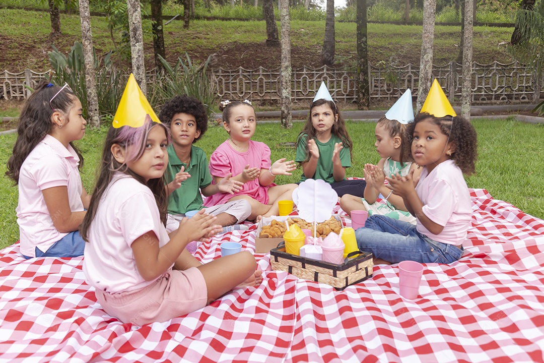 Lindas crianças felizes usando chapéu de aniversário